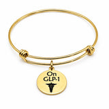 On GLP-1 Goldtone Notice Charm Bracelet
